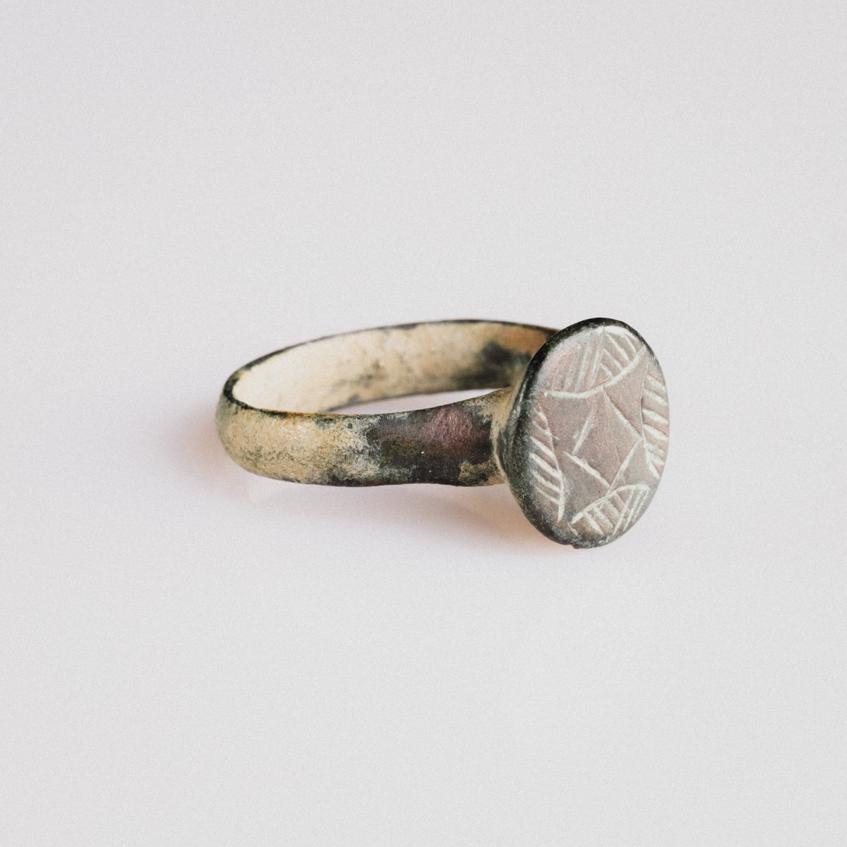 Medieval bronze ring 'Aldric' front view showing raised circular bezel and hatched geometric device