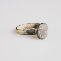 Medieval bronze ring 'Aldric' front view showing raised circular bezel and hatched geometric device