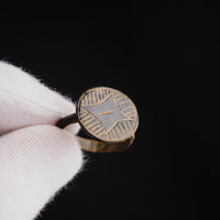 Medieval bronze ring Aldric held in gloved hand highlighting bezel engraving detail