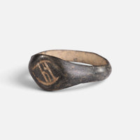 Medieval bronze ring 'Arnulf' shows its incised bezel device from the opposite front angle.