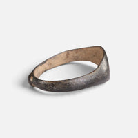 Medieval bronze ring 'Arnulf' shows its broad inner shoulder and the back of its hoop at an angle.