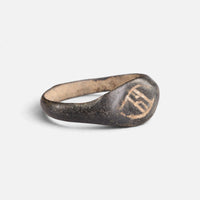 Medieval bronze ring 'Arnulf' shows its angular bezel engraving and broad shoulder at an angle.