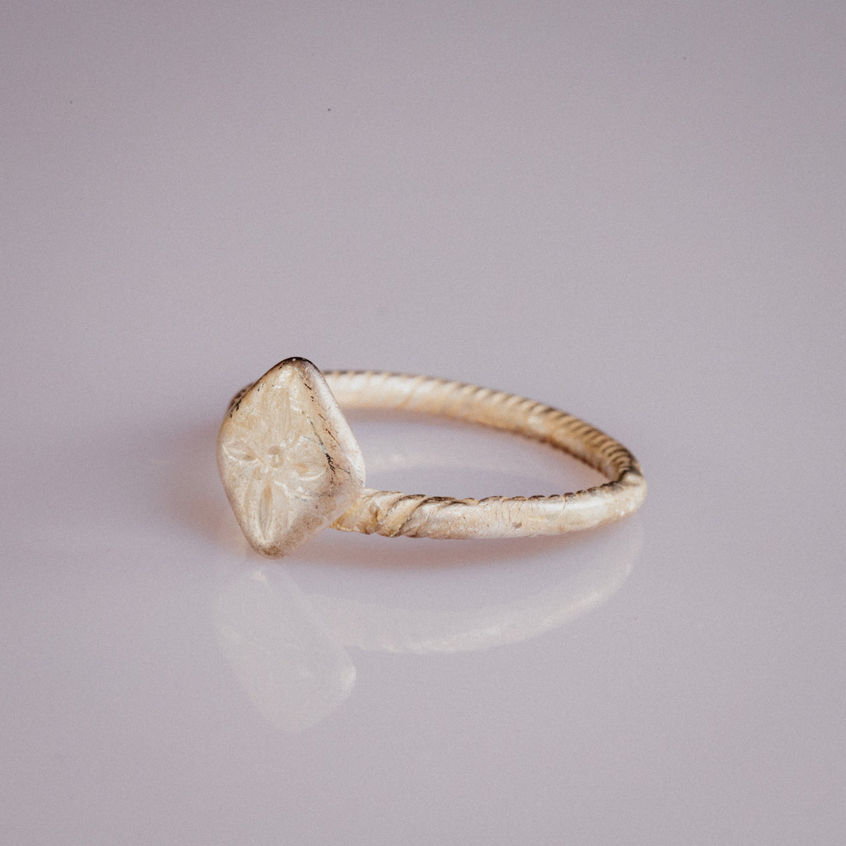 Medieval bronze ring Florentia angled view of engraved quatrefoil bezel and twisted band