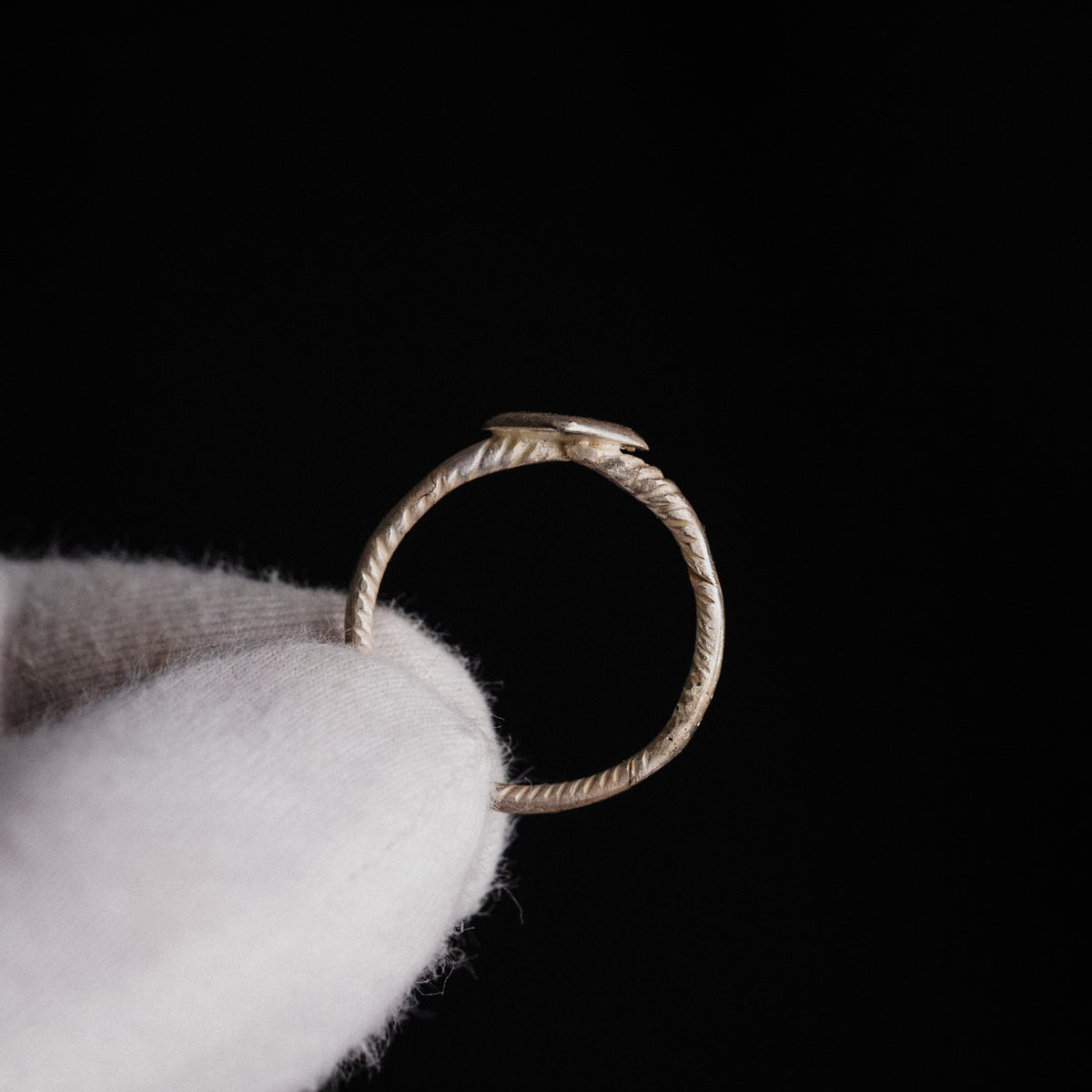 Medieval bronze ring Florentia held upright showing lozenge bezel and cable hoop silhouette