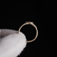 Medieval bronze ring Florentia held upright showing lozenge bezel and cable hoop silhouette