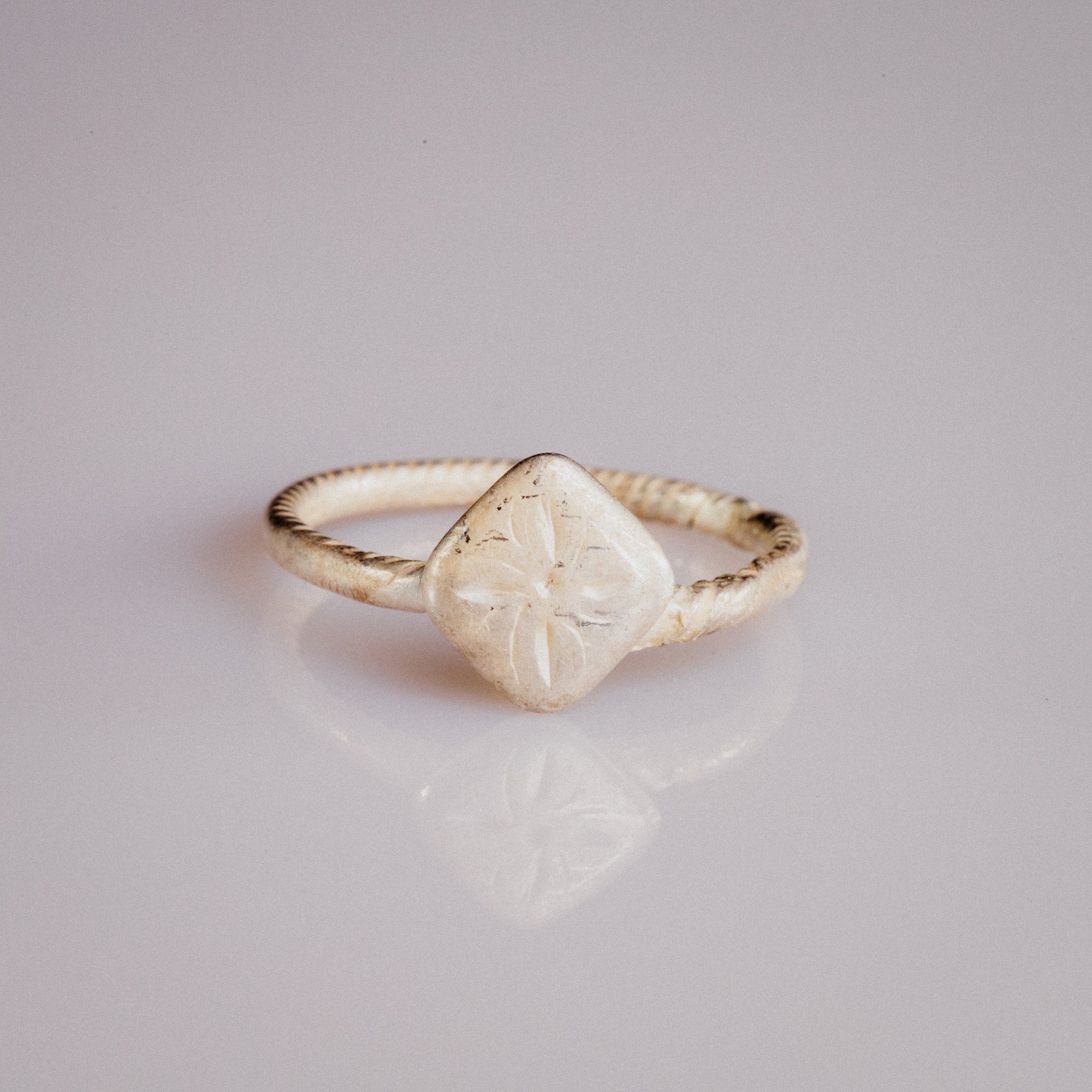 Medieval bronze ring Florentia with quatrefoil lozenge bezel and twisted cable hoop, top view