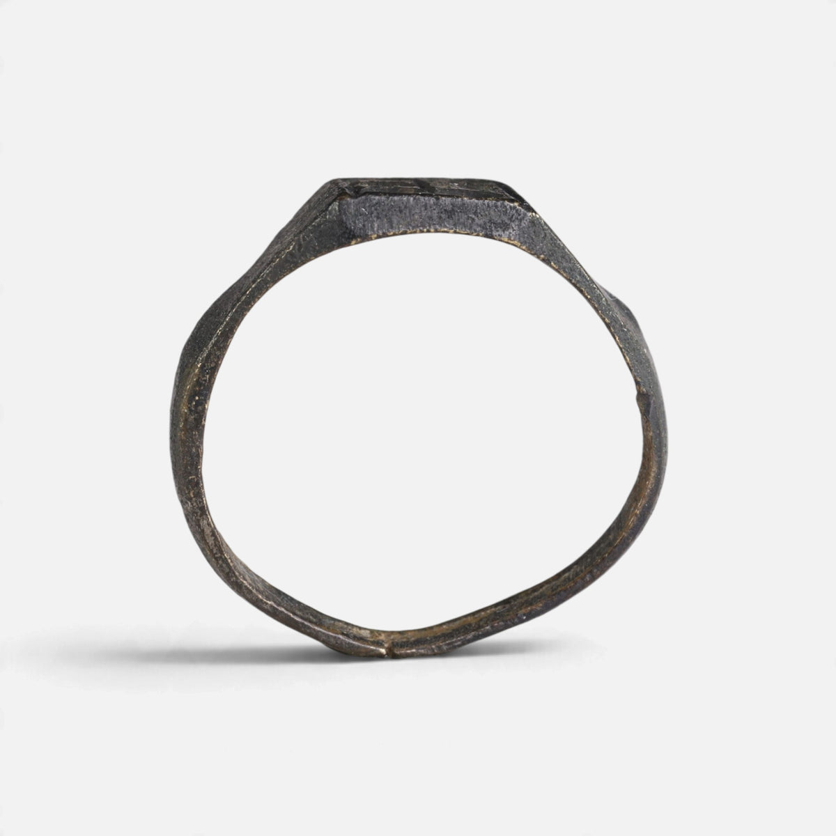 Medieval bronze ring 'Radomar' shows its complete hoop and the rectangular bezel edge in profile.
