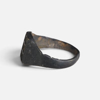Medieval bronze ring 'Radomar' shows its rectangular bezel edge and broad shoulder from the side.