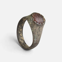 Medieval bronze ring 'Radwina' shows its reddish setting and engraved broad shoulder above the full hoop.