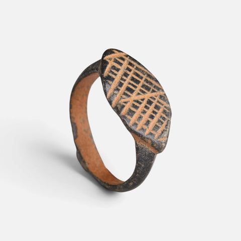 Medieval bronze ring 'Rhombulus' shows its cross-hatched navette bezel and complete hoop at an angle.