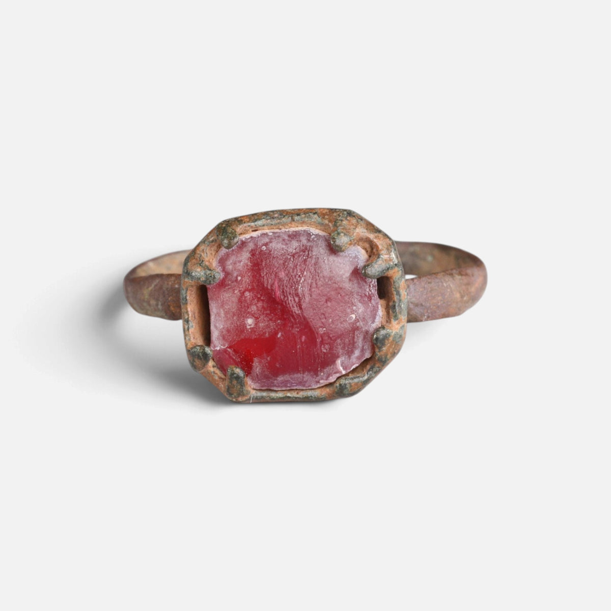 Medieval bronze ring 'Rutheris' shows the red face of its setting from the front.