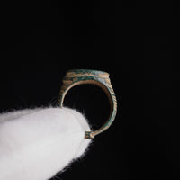 Medieval bronze ring Tamgar in profile against black background showing hoop