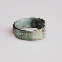 Medieval bronze ring Vesna viewed along the hoop, revealing all-over punched-dot ornament