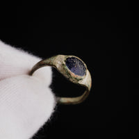 Medieval bronze ring Vespertin close-up macro of the dark purplish glass paste cabochon