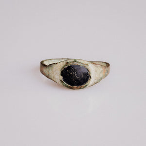 Medieval bronze ring Vespertin with dark glass paste cabochon in oval cup bezel, top view