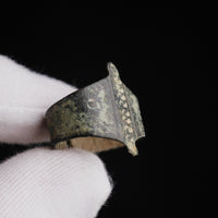 Medieval bronze ring Wistanoc, held in a gloved hand, side view of the punched bar and one projecting tab