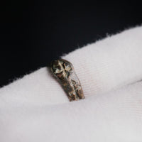 Medieval bronze ring Radenko resting on a gloved hand, engraved crosses visible along the band