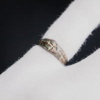 Medieval bronze ring Radenko on a gloved hand, third angle showing the worn band surface