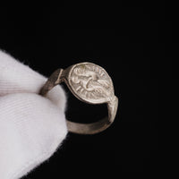 Medieval silver ring Wistrid held in a gloved hand, side view of the bezel and hoop