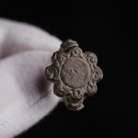 Face-on view of medieval bronze ring Rosalind, eight scrolled lobes around an illegible central field