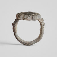 Front view through the hoop of medieval bronze ring Rosalind, showing the bezel edge and knobbed shoulders