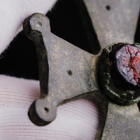 Detail of one arm with its knob terminal beside the central collet of medieval bronze cross pendant 'Gemmata'