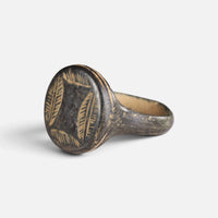 Medieval bronze ring 'Ventaris' shows its leaf-like bezel engraving from the opposite front angle.