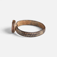 Medieval bronze ring 'Luminara' shows its setting edge and marked band from the opposite side.