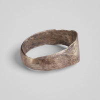 Silver band ring 'Ovata' shows its widening band and a worn shoulder field from the side.