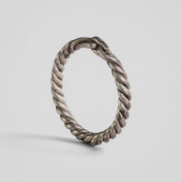 Medieval silver twisted-wire ring Hravnar standing upright, showing the loop-and-bar closure at the top
