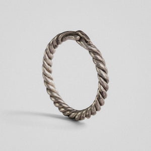 Medieval silver twisted-wire ring Hravnar standing upright, showing the loop-and-bar closure at the top
