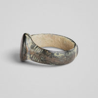Opposite side of medieval bronze ring 'Wistan' with herringbone incisions visible