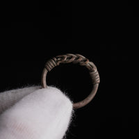 Roman silver wire ring 'Nodus' shows the inside of its hoop and wound collars while held in a glove.