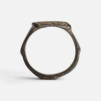 Medieval Islamic bronze ring 'Rashida' shows its complete hoop and the rectangular bezel edge in profile.