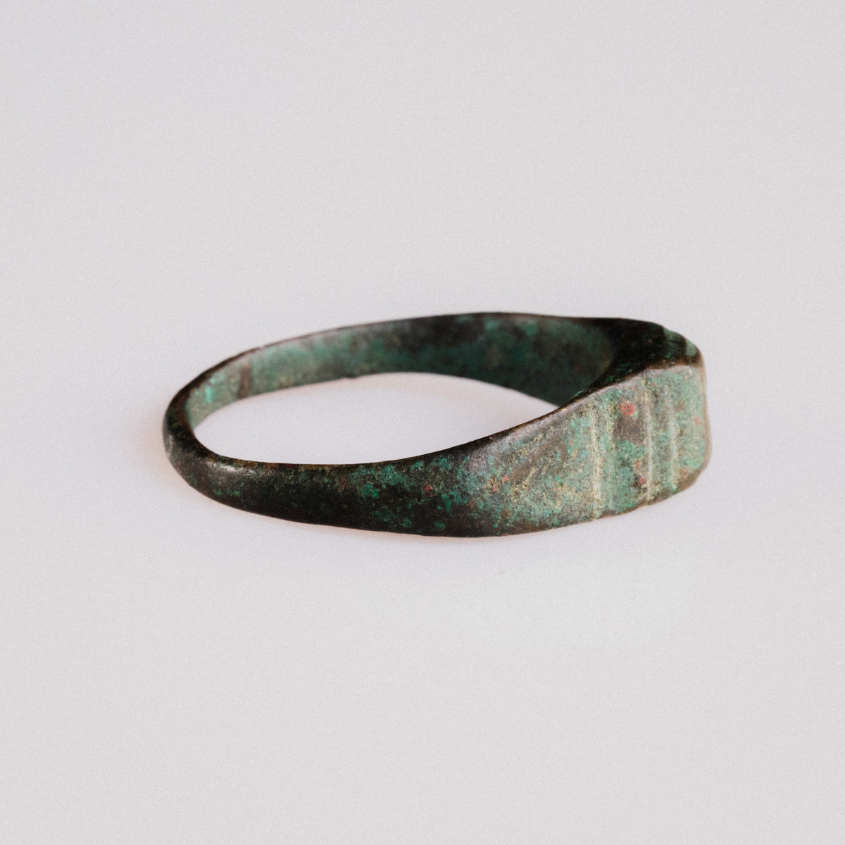 Profile of Roman bronze ring Numerius revealing tapered D-section hoop and malachite patina