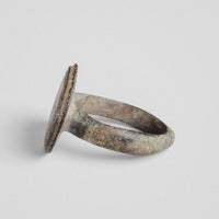 Profile view of Byzantine bronze ring Xenaros showing D-section hoop and earth accretions