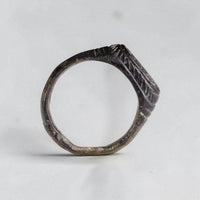 Profile view of medieval bronze ring Vespasia showing D-section hoop and engraved shoulders