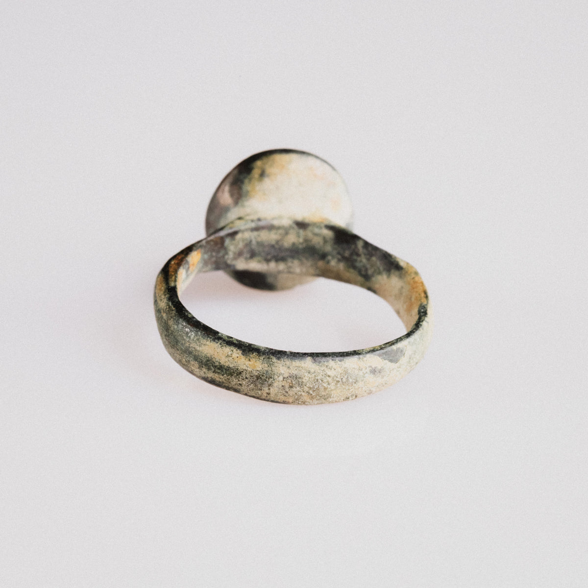 Rear view of medieval bronze ring 'Aldric' with malachite patina and calcareous soil deposits