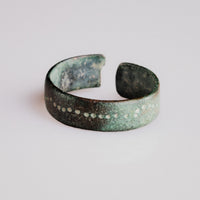Rear view of medieval bronze ring Vesna showing malachite patina and open penannular form