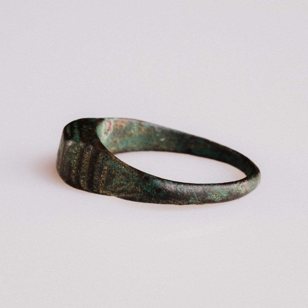 Reverse angle of Roman bronze ring Numerius with layered malachite and cuprite patina
