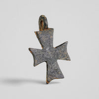 Reverse of medieval bronze cross pendant 'Okellaris' with smooth worn surface