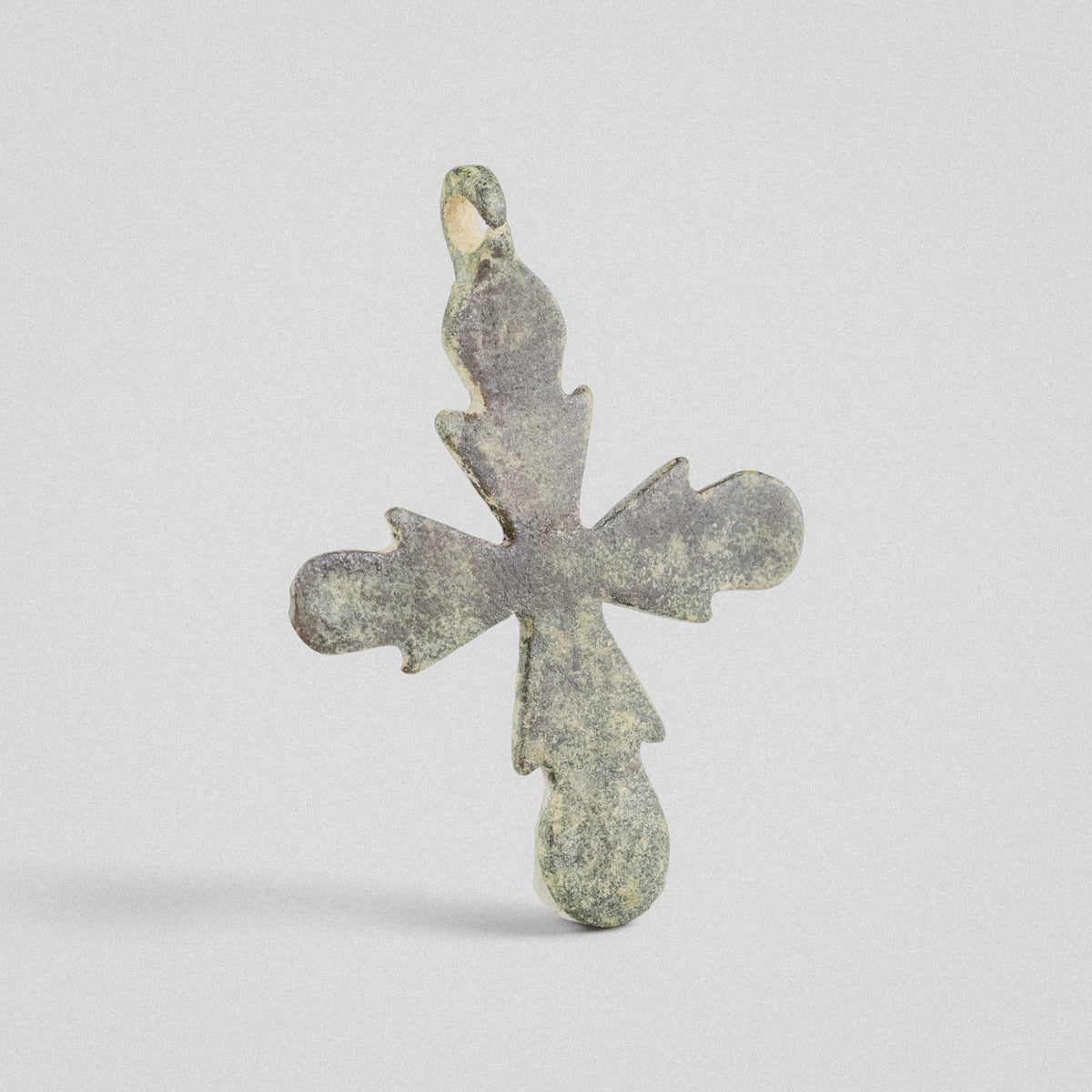 Reverse of Medieval bronze cross pendant 'Rotunda' showing plain flat plate and budded arm terminals
