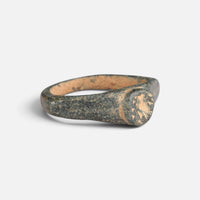 Roman bronze ring 'Aquilarius' shows its circular bezel and broad shoulder at an angle.
