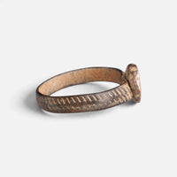 Medieval bronze ring 'Luminara' shows its setting edge and diagonally marked band from the side.