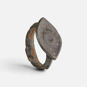 Roman bronze ring 'Catulla' shows its circular navette decoration and complete hoop at an angle.