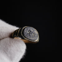 Roman bronze ring Leonis held in gloved hand showing lion intaglio detail