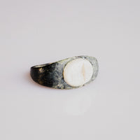 Roman bronze ring Numerius showing tapered shoulders and pale intaglio stone, three-quarter view