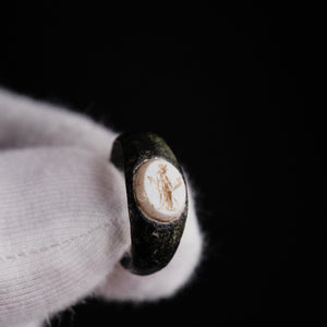 Roman bronze ring Velthur, macro close-up of Mercury intaglio with petasos, caduceus and purse