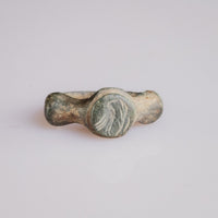 Roman bronze signet ring Corvidus with engraved bird motif on circular bezel, front view