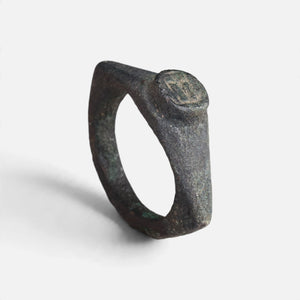 Roman bronze ring 'Hesperia' shows its small round bezel and complete angular hoop at an angle.